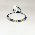 PULSO TEJIDO CON 9 BALINES DE TRES ORO 18K CON BOLA DE NEOPRENO EN HILO NEGRO