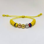 PULSO TEJIDO7 BALINES TRES ORO 18K CON BOLAS DE NEOPRENO EN HILO AMARILLO
