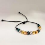 PULSO TEJIDO CON 9 BALINES DE ORO 18K CON BOLAS DE NEOPRENO EN HILO NEGRO