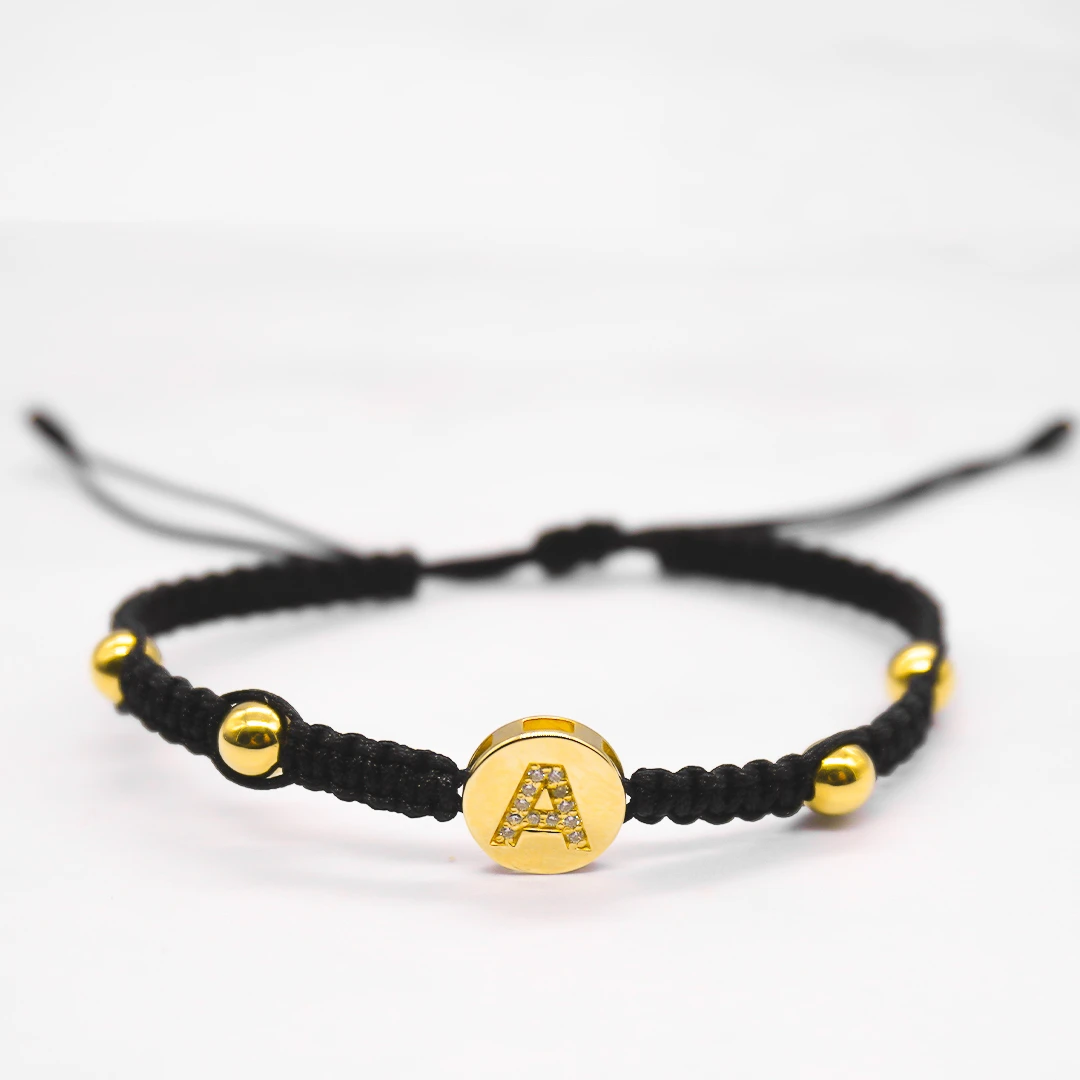 OR151-0426pulso.webp PULSO TEJIDO CON DIJE HERRAJE LETRA A CON 4 BALINES NÚMERO 5 EN ORO 18K - Image 1