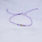 PULSO TEJIDO CON TRES BOLAS DE ORO