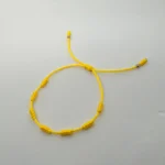 PULSO TEJIDO CON 7 NUDOS EN COLOR AMARILLO CON 2 BALINES DE ORO 18K
